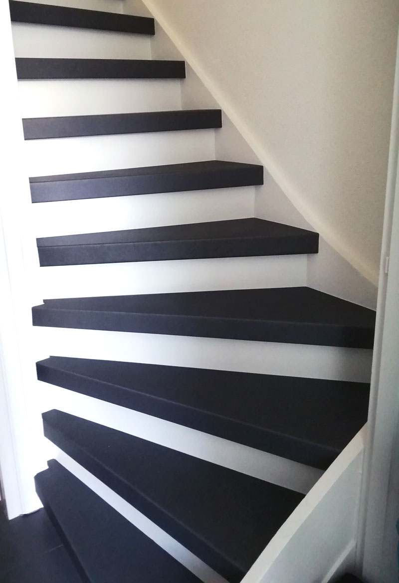 Afbeelding waarin de een volledige trap met zwarte overzettreden zichtbaar is