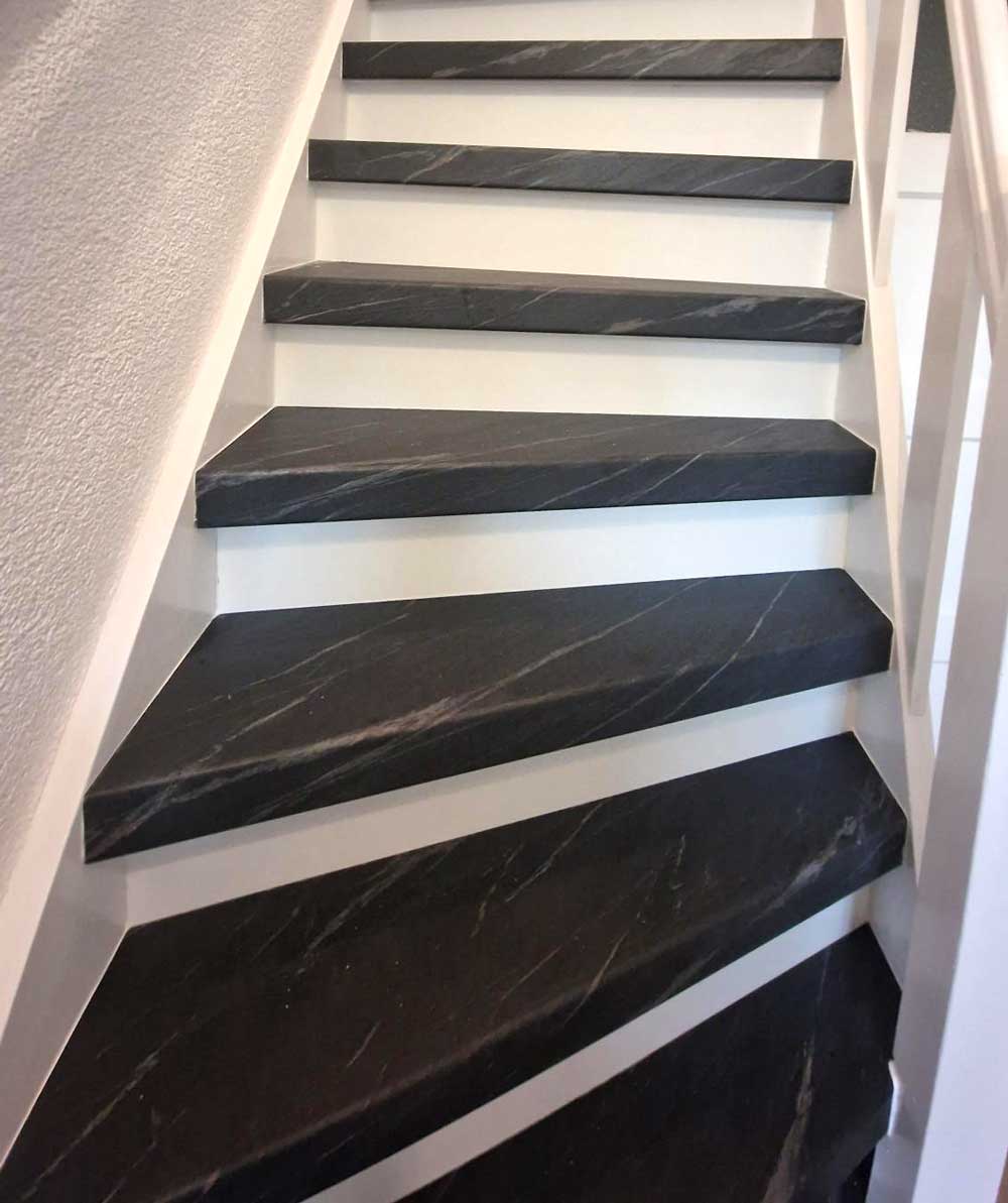 Zwarte trap met marmer look overzettreden en witte stootborden